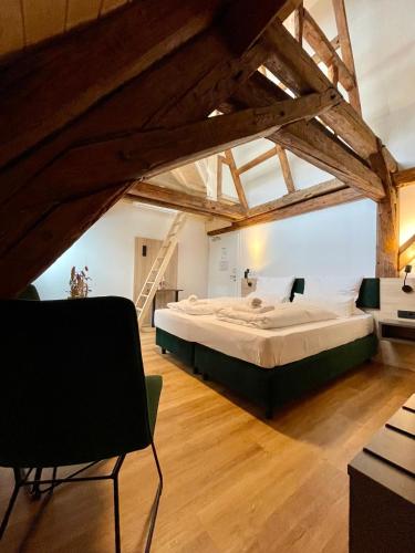 a large bed in a large room with wooden floors at Hopfenhotel am Adenauerufer in Bamberg