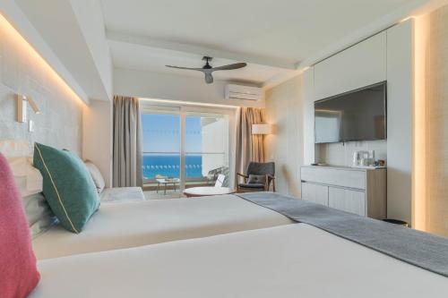- une chambre avec un grand lit et une vue sur l'océan dans l'établissement Pestana Blue Alvor Beach - All Inclusive Hotel, à Alvor