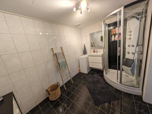 ein Bad mit einer Dusche und einem Waschbecken in der Unterkunft Lovely home by Glomma river! in Vidnes