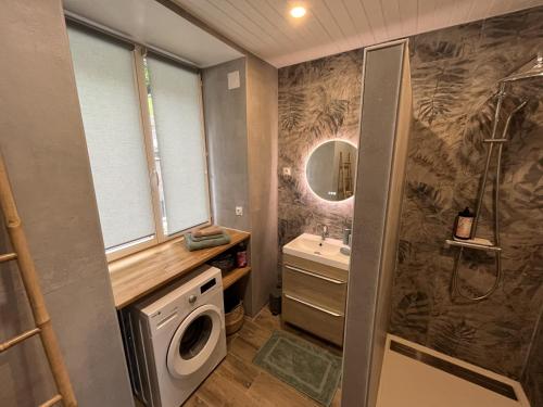 y baño con ducha, lavabo y lavadora. en Gîte à Saint-Marcan-Baie du Mont-Saint-Michel en Saint-Marcan
