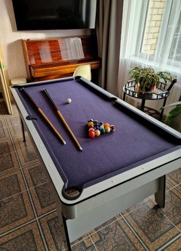 a pool table with bats and balls on it at Guest House BENHAUS ar pirti un āra kublu in Sarkaņi