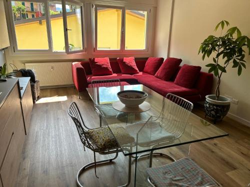 a living room with a red couch and a glass table at Varenna Guest House in Varenna