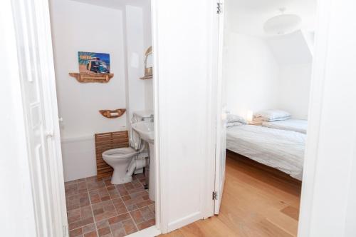 a bathroom with a toilet and a sink and a bed at Barton Road Apartment in Woolacombe