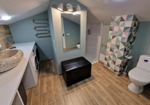 a bathroom with a toilet and a sink at Guest House BENHAUS ar pirti un āra kublu in Sarkaņi
