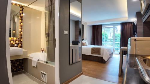 バンコクにあるAspira Suites Sukhumvit 20のバスルーム(ベッド1台、バスタブ、シンク付)