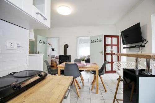 a kitchen and living room with a table and chairs at Levendula Apartman Berekfürdő in Berekfürdő
