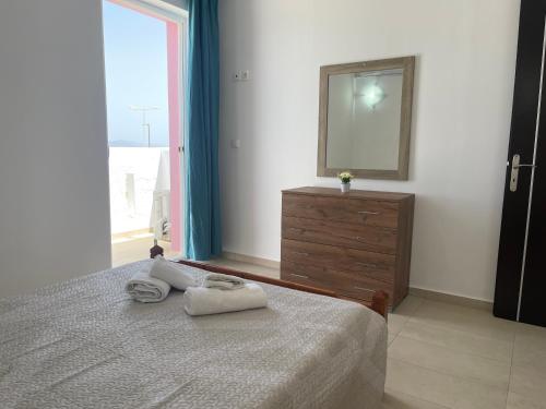 a bedroom with a bed and a mirror and a dresser at Majestic Sunset in Mastichari