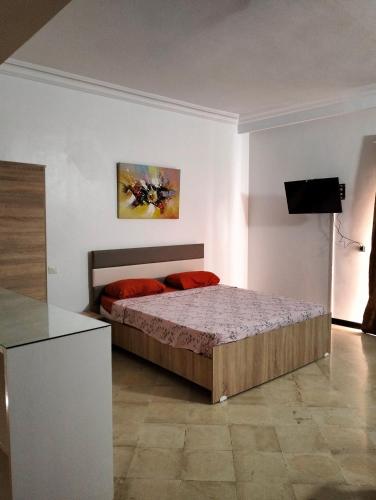 een slaapkamer met een bed met rode kussens erop bij 119 camus 120 in Houmt Souk