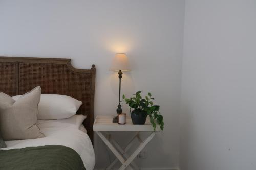 a bedroom with a bed and a table with a plant at Retreat on Fig Street in Dromana