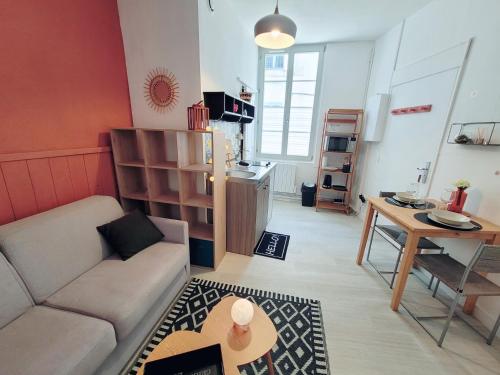 Studio hypercentre proche Vieux Marché في لا روشيل: غرفة معيشة بها أريكة وطاولة