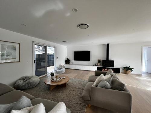 a living room with two couches and a tv at Retreat on Fig Street in Dromana