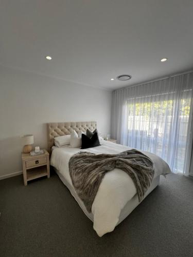a bedroom with a large bed with a large window at Retreat on Fig Street in Dromana