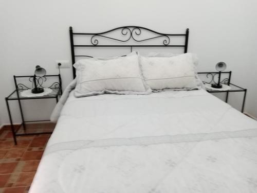 1 Schlafzimmer mit einem weißen Bett und 2 Nachttischen in der Unterkunft Casa Emilia in Almería