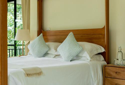 a bedroom with a bed with white sheets and pillows at The Cove in Panwa Beach