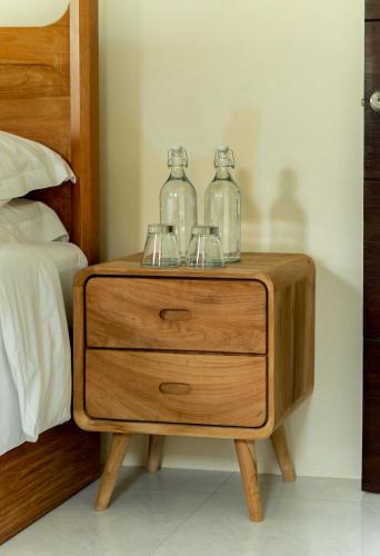 a wooden night stand with two glass jars on it at The Cove in Panwa Beach