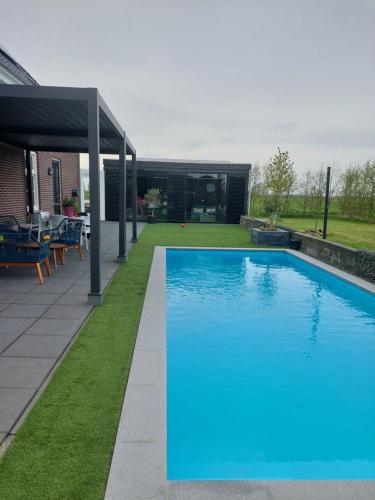 a large blue swimming pool in a yard at Dinie's Bed en Brood in 's-Heerenbroek