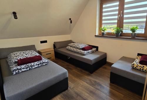 dwa łóżka i kanapa w pokoju w obiekcie Daj spokój w Bieszczadach - całoroczny 7 osobowy domek z jacuzzi 884 - 367 - 792 w Polańczyku