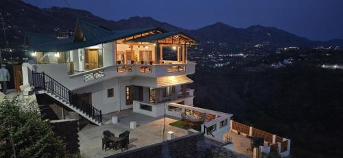 a house with a view of a city at night at Laspa Cottage, Bhimtal in Bhīm Tāl