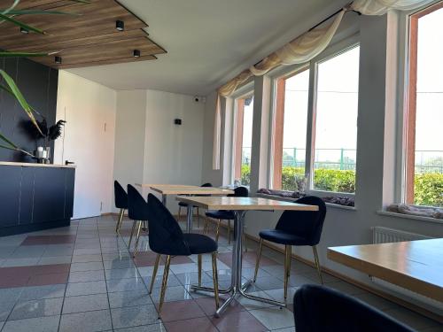 una sala da pranzo con tavoli, sedie e finestre di KARAT a Malbork