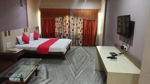 Habitación de hotel con cama y escritorio. en HOTEL SHRI KRISHN, en Betūl