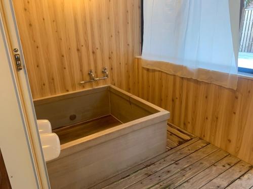 a bath tub in a wooden bathroom with a window at AKAYA GLAMPING HOUSE - Vacation STAY 41979v in Fukuro