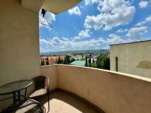 a balcony with a table and chairs and a view at Apartment Lubliana in Tbilisi City