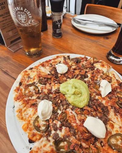a pizza sitting on top of a table with ice cream at Beach Walk by Salted Fynbos Staying in Pearly Beach