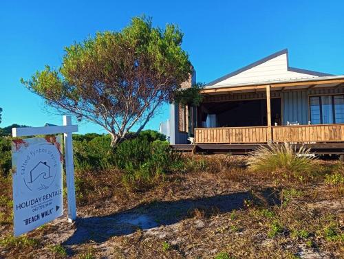 a house with a sign in front of it at Beach Walk by Salted Fynbos Staying in Pearly Beach
