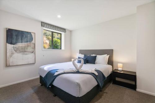 a bedroom with a large bed and a window at Luxury Retreat - Matakauri in Queenstown