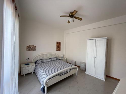 une chambre avec un lit et un ventilateur de plafond dans l'établissement PIETRA BIANCA, à Acireale