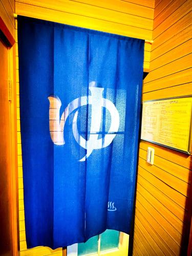 a blue shower curtain with a white logo on it at GranGiorno HAKONE Kowakidani in Ashinoyu