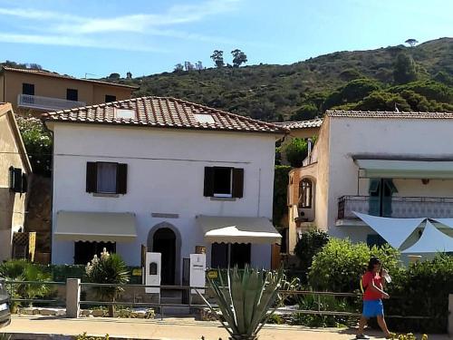 a woman standing in front of a white house at Violetta 1 in Campese
