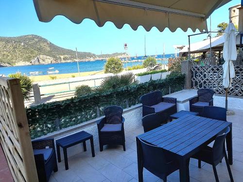 a patio with tables and chairs and a view of the ocean at Violetta 1 in Campese