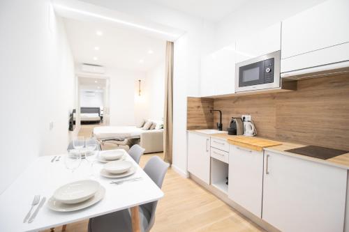een keuken en woonkamer met een tafel en stoelen bij BedTime Suites by Concept Flats in Valencia