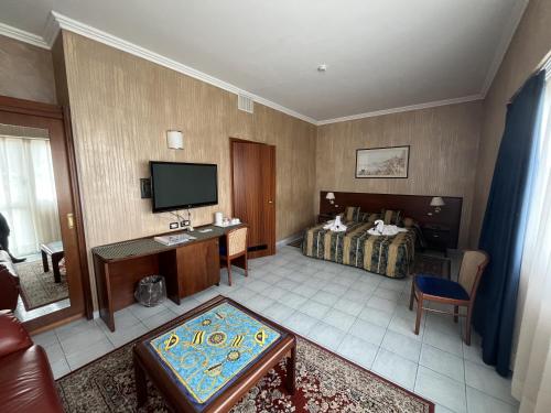 a hotel room with a bed and a television at Grand Hotel L'Approdo in Terracina