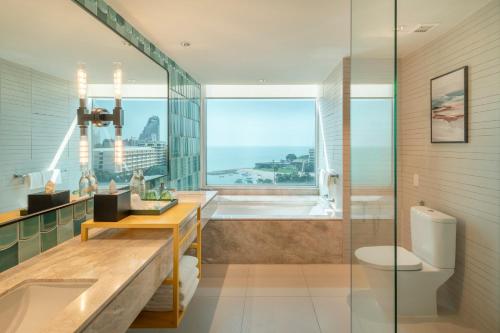 baño con bañera y ducha con ventana en Holiday Inn Pattaya, an IHG Hotel en Pattaya centro