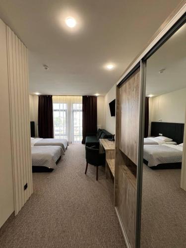 Una habitación de hotel con dos camas y un espejo. en Гетьман Готель & SPA, en Chortkiv