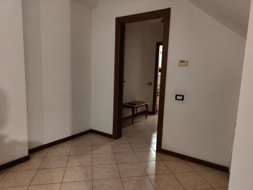 an empty hallway with a door and a table at Host4ALL Bixio Cuore di Falconara in Falconara Marittima