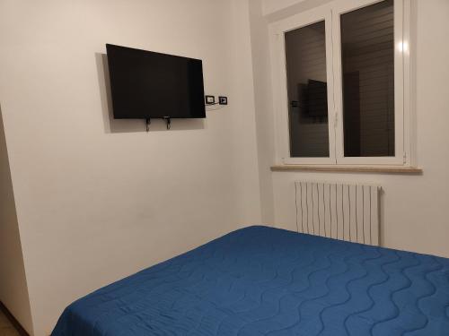 a bedroom with a bed and a tv on the wall at Host4ALL Bixio Cuore di Falconara in Falconara Marittima
