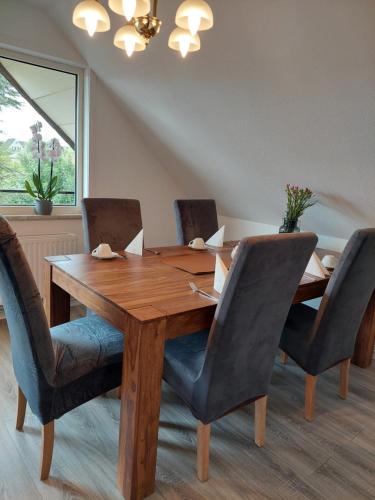 een eettafel met stoelen en een houten tafel bij Cozy Home in Heide, Schneverdingen in Schneverdingen