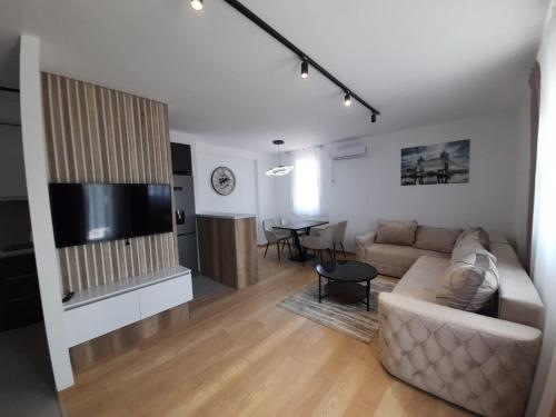a living room with a couch and a dining room at Apartman Petra in Niš