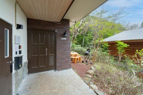 a garage with a brown door and a table at GranGiorno HAKONE Kowakidani in Ashinoyu