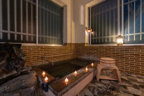 a bath tub with candles and a stool in a room at GranGiorno HAKONE Kowakidani in Ashinoyu