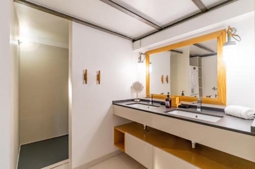 une salle de bain avec deux lavabos et un miroir dans l'établissement L'Arsenal - très bel appartement sur le Vieux-Port, à Marseille