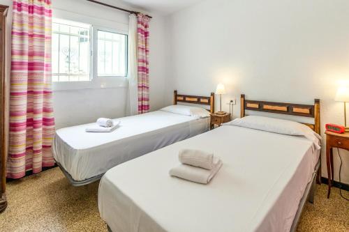 2 camas en una habitación pequeña con ventana en Carboneras 48 Apartamento en primera línea de mar, en Girona