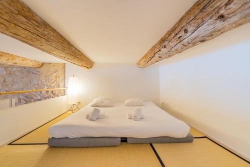 - une chambre avec un lit blanc dans l'établissement L'Arsenal - très bel appartement sur le Vieux-Port, à Marseille