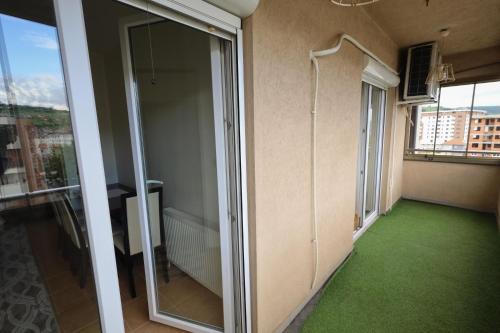 an empty room with a green floor and glass doors at Duran Apartmani in Novi Pazar
