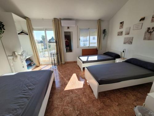 a bedroom with two beds and a living room at Triplex con piscina en S. Javier in San Javier