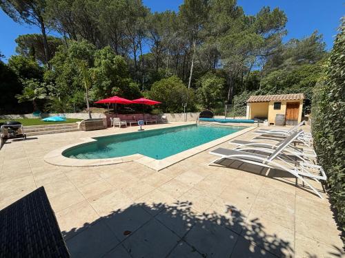 - une piscine avec des chaises, une table et un parasol dans l'établissement Villa entre mer et golf, à Saint-Raphaël