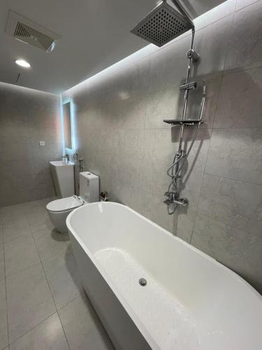 a bathroom with a bath tub and a toilet at اكواخ وشاليهات لوزان الريفية 2 in Dahaban